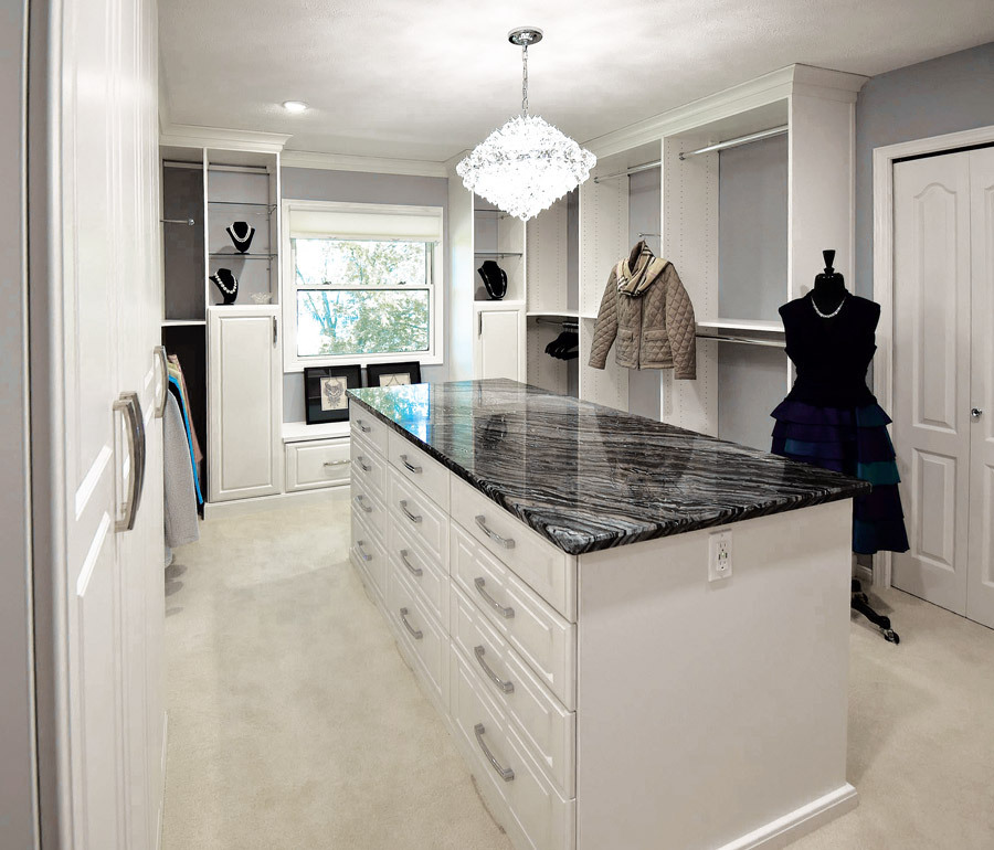 Custom Closets of Georgia closet with white cabinetry, chrome rods, and a triple island topped with black quartz